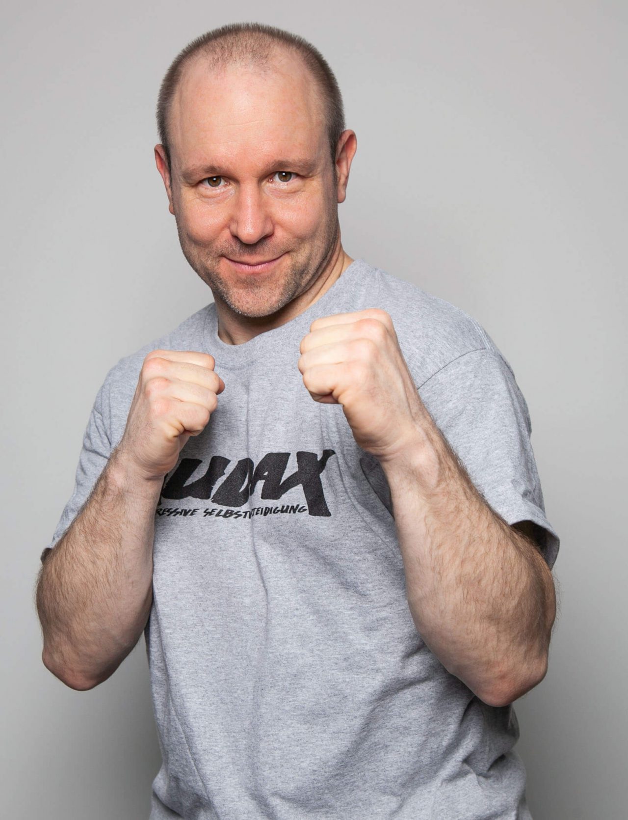 Kickbox und MMA Trainer Jan steht in Kampfstellung und lächelt